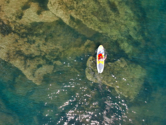 A top-down view of a man paddleboarding